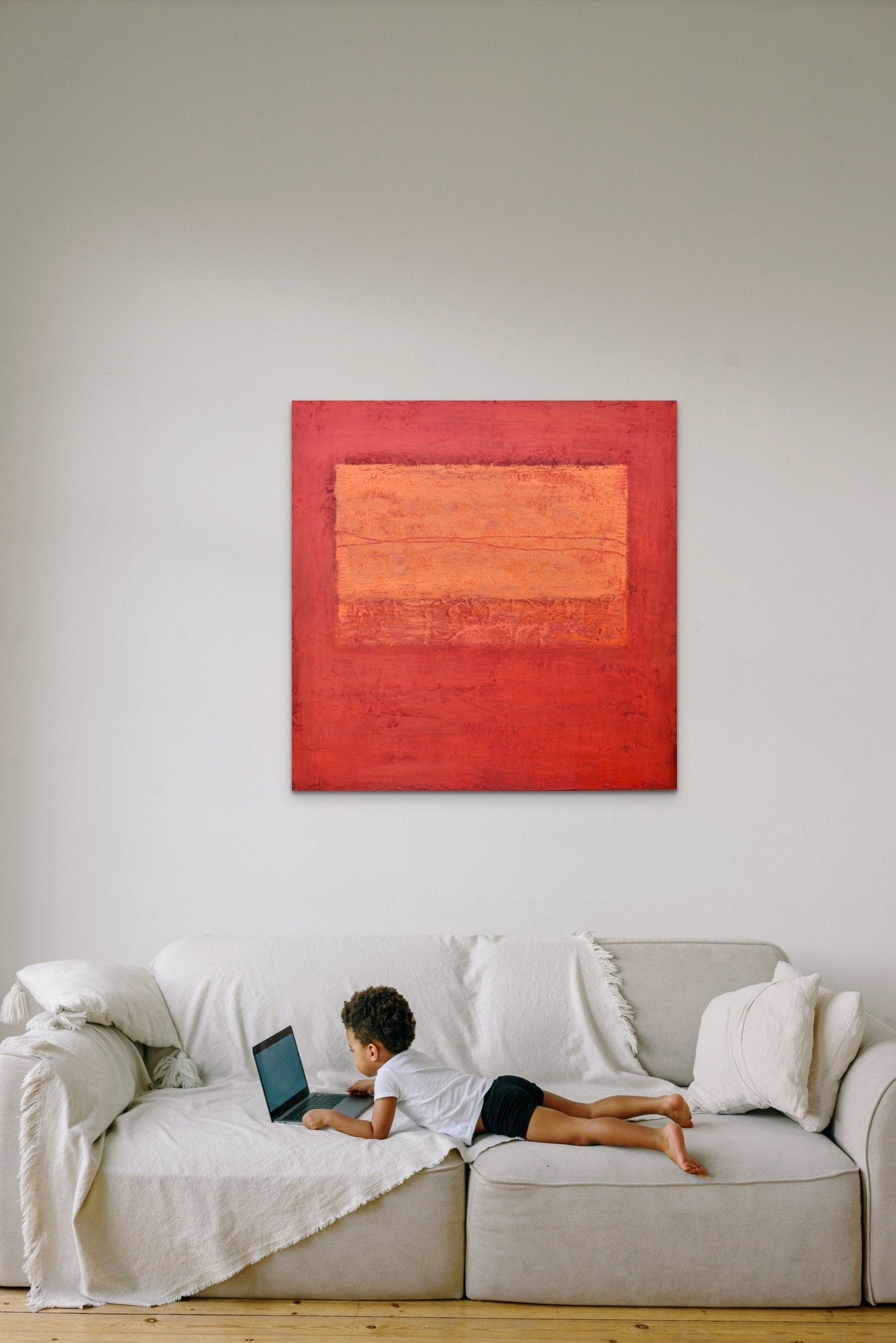 Abstract artwork in orange & red fills this cozy room with life and energy