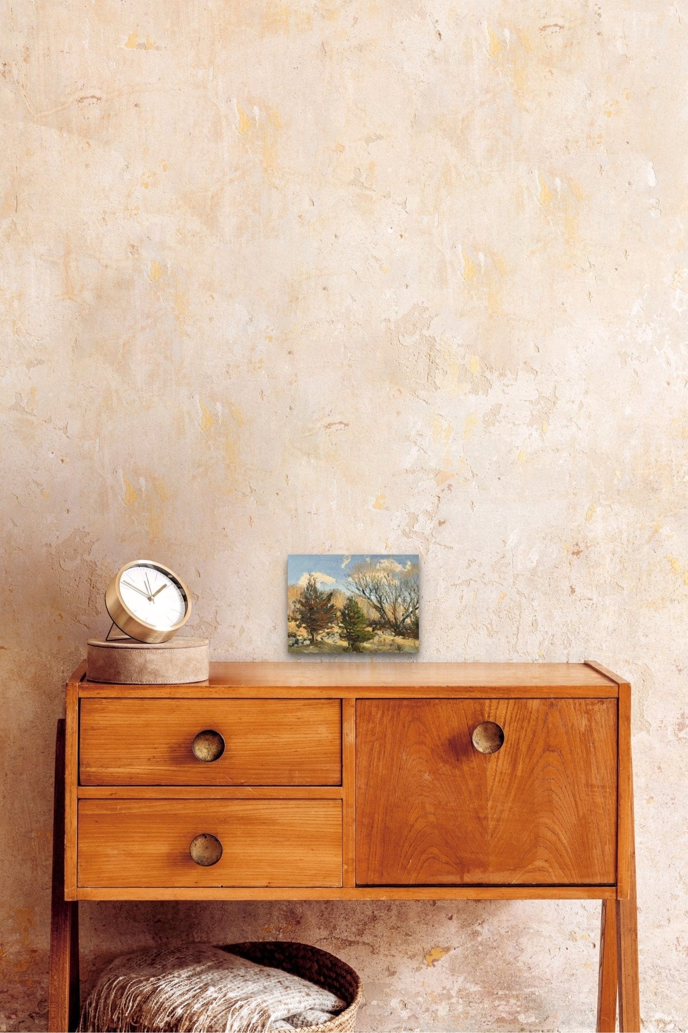 Landscape artwork filled with trees of New England adds nature to this cozy space