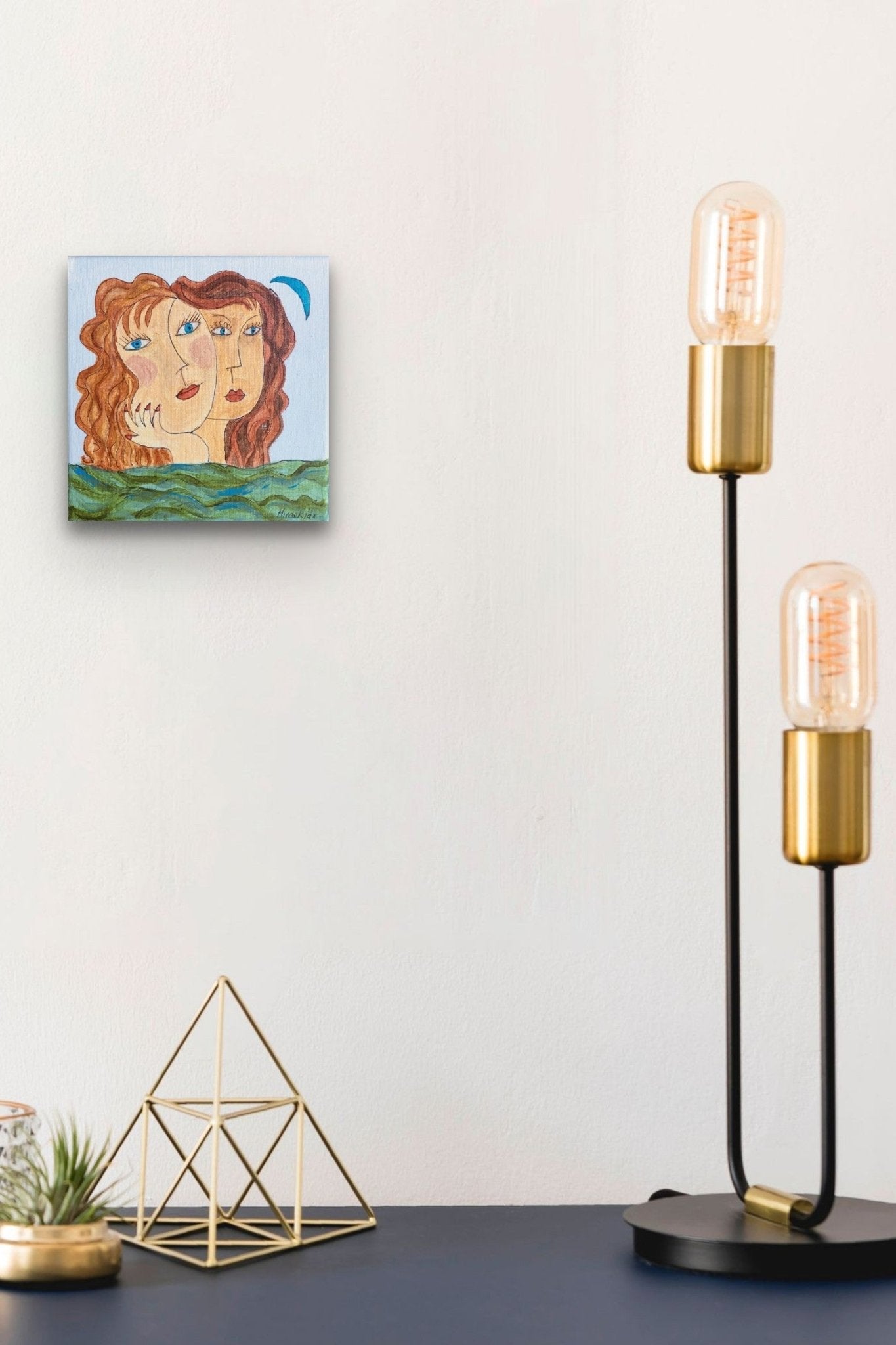 Portrait artwork with blue, brown & green colors fills this small space with friendliness