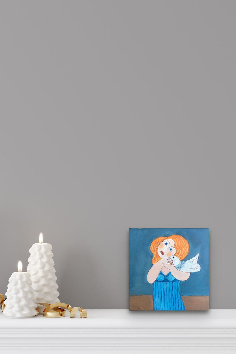 Small Female Figurative artwork adds blue color to this white mantle with candles